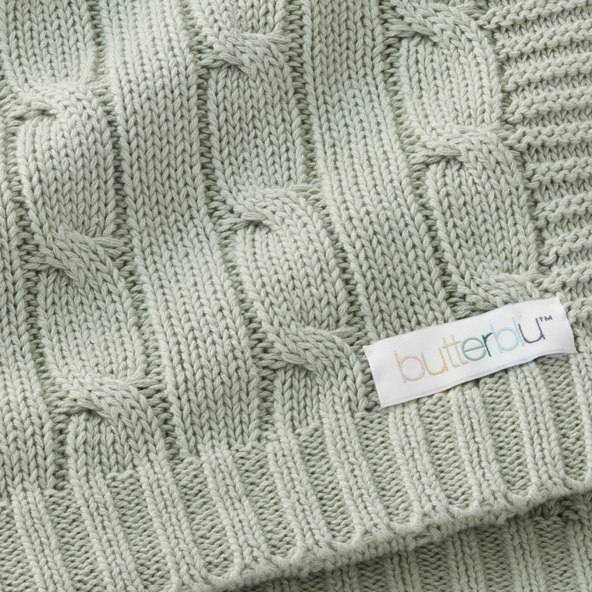 Close-up of a green knitted fabric with a 'butterau' label.