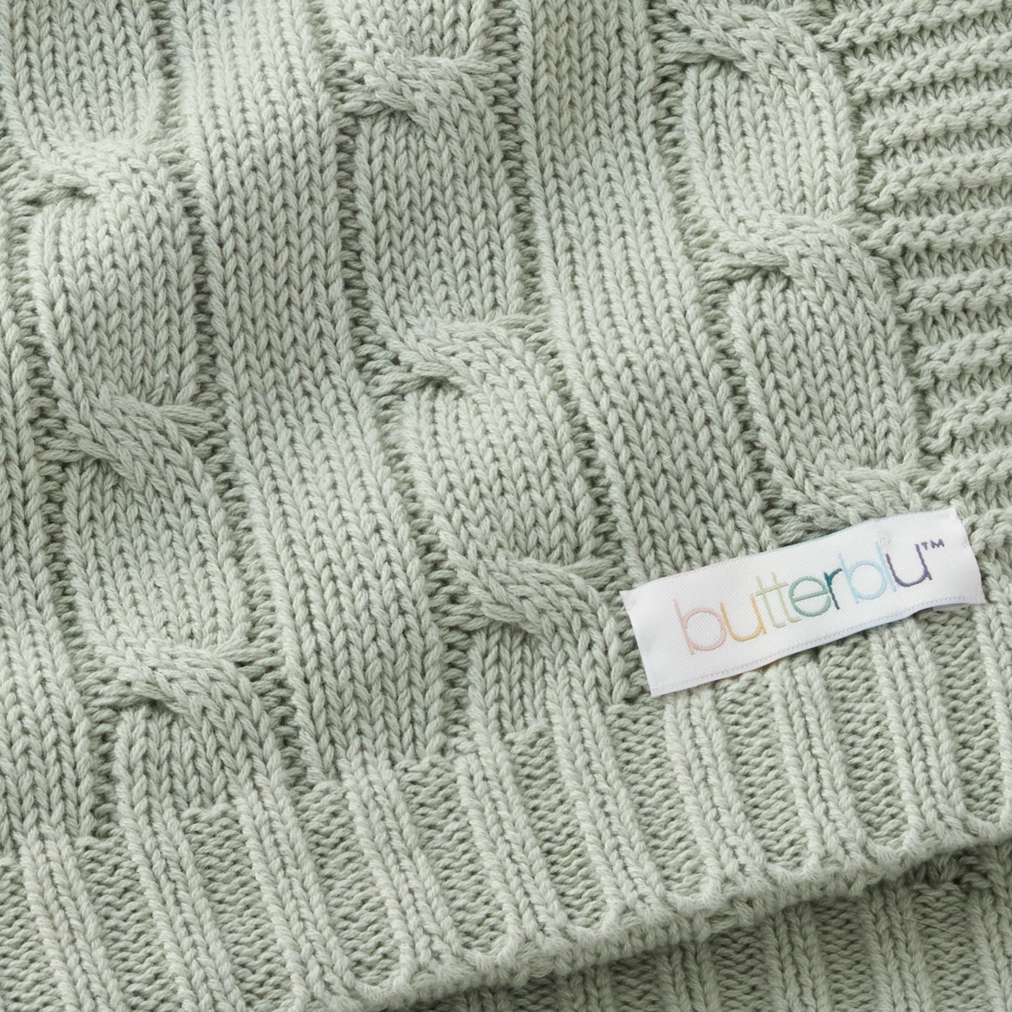 Close-up of a green knitted fabric with a 'butterau' label.