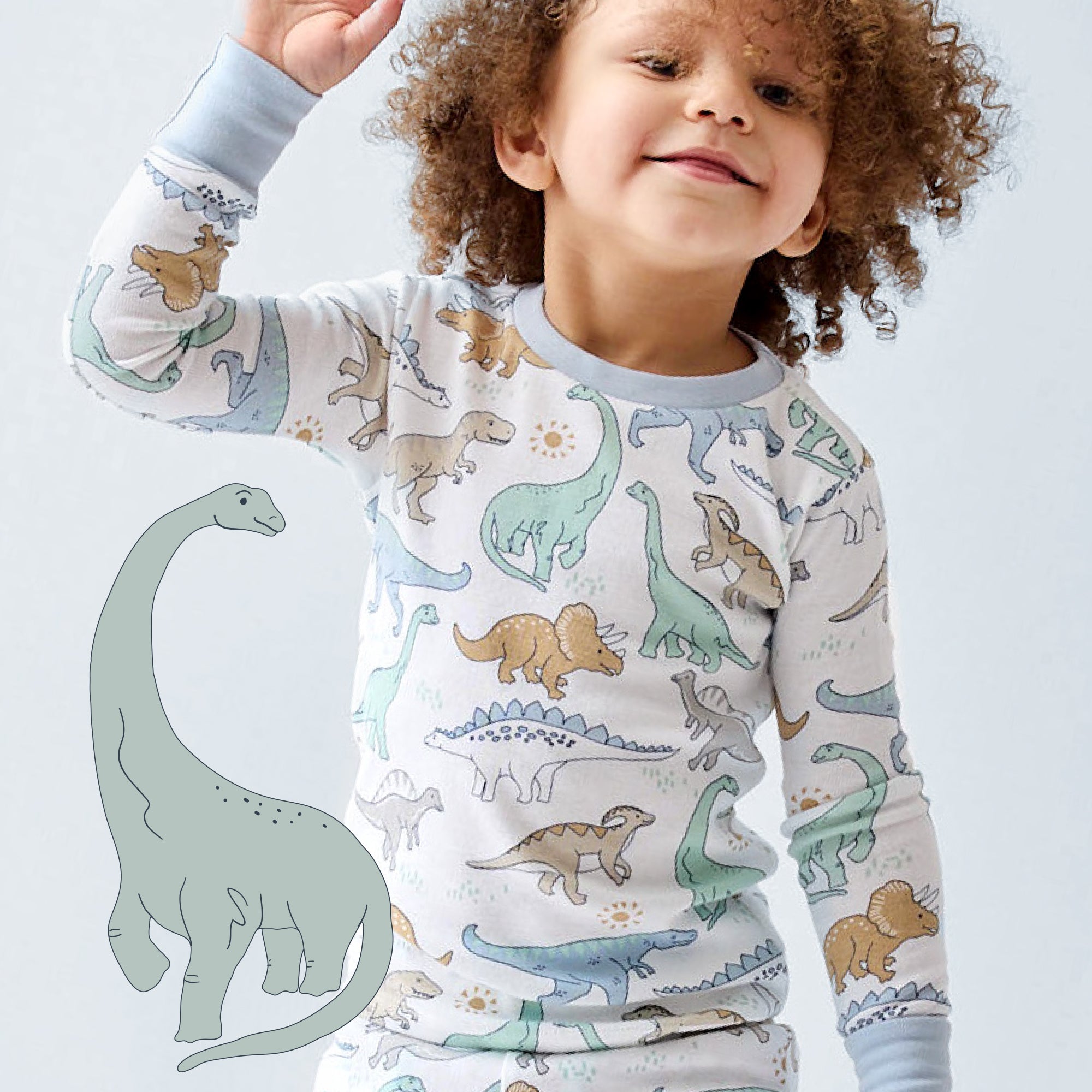 Child wearing dinosaur-themed pajamas with a toy dinosaur on a light gray background