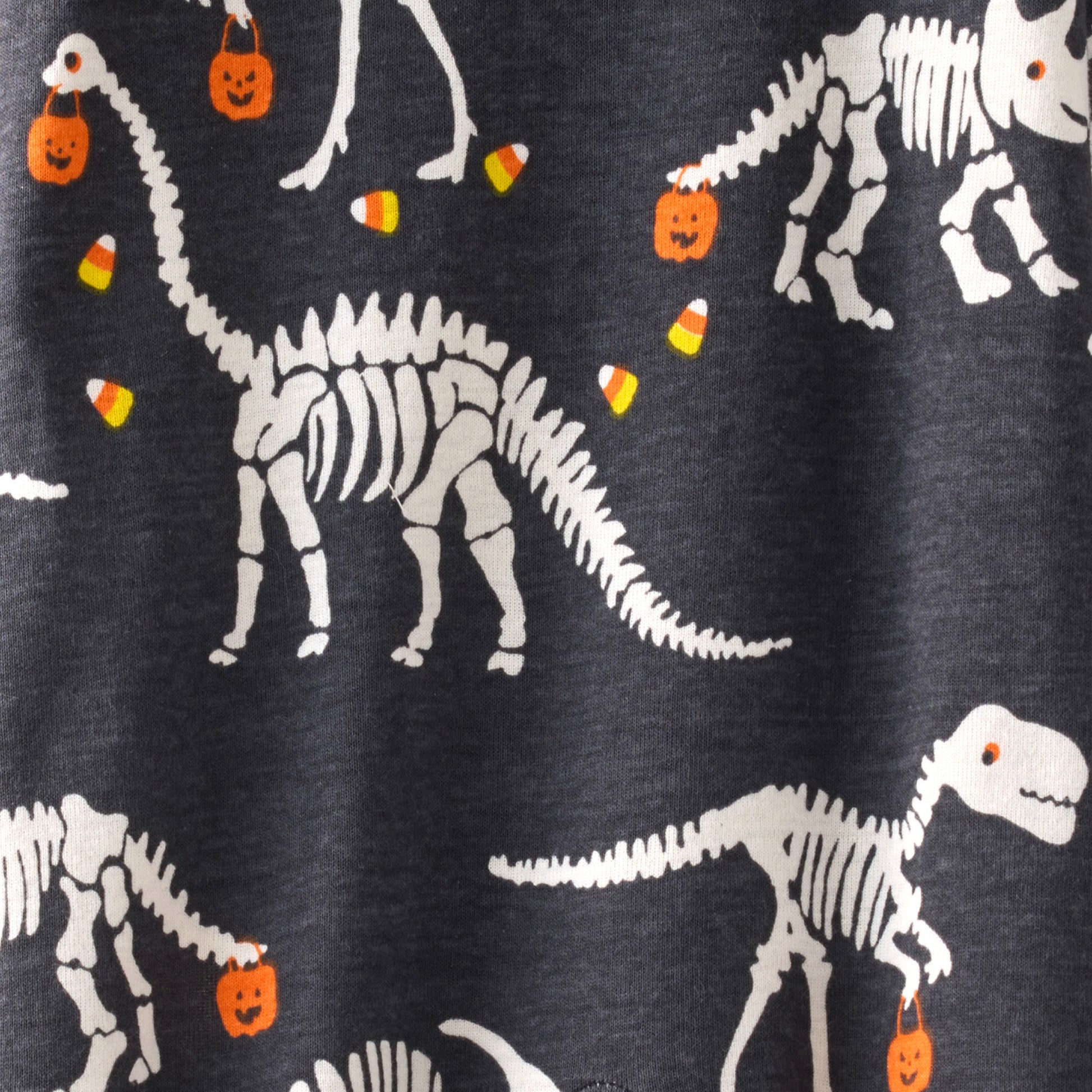 Dinosaur skeletons with Halloween elements on a dark background