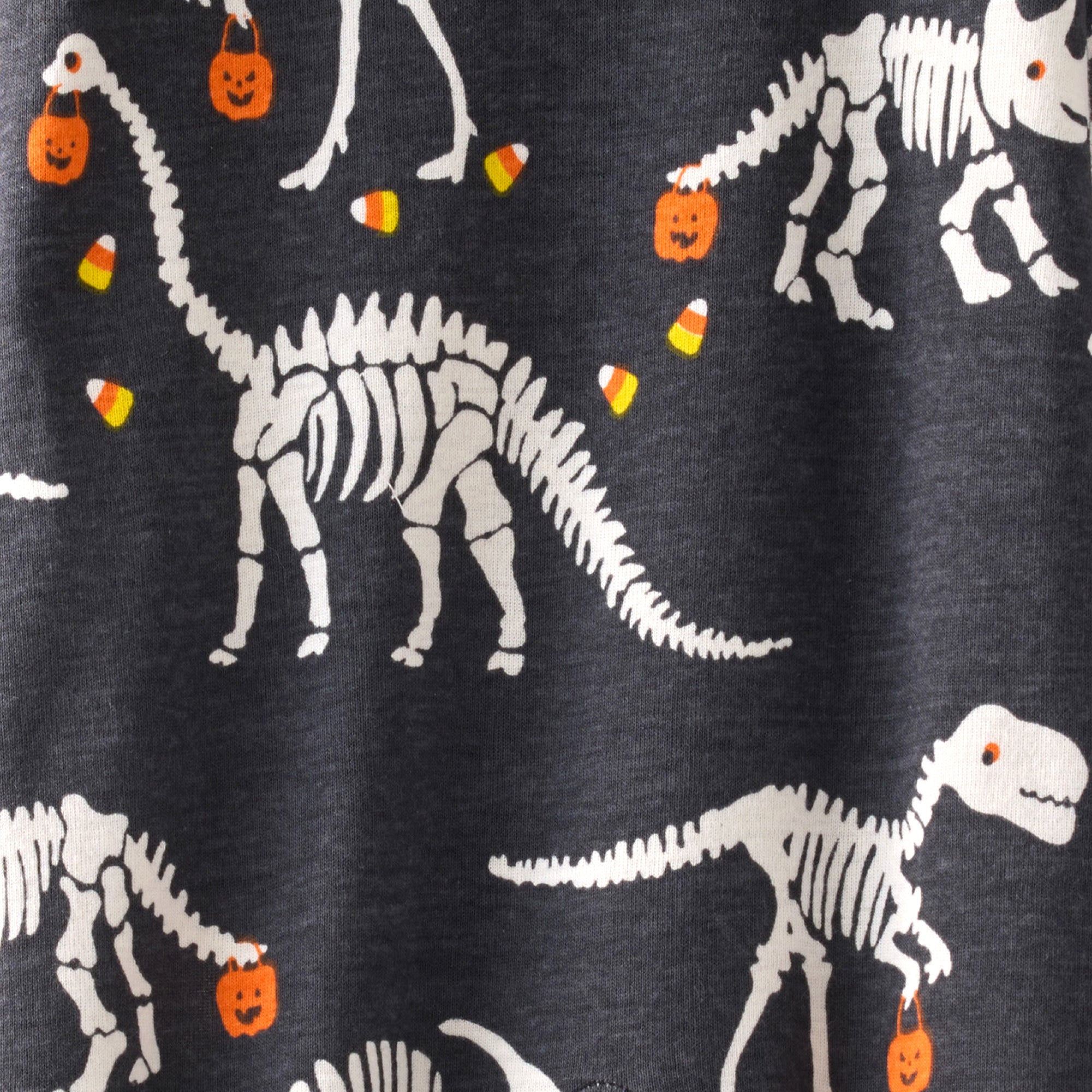 Dinosaur skeletons with Halloween elements on a dark background