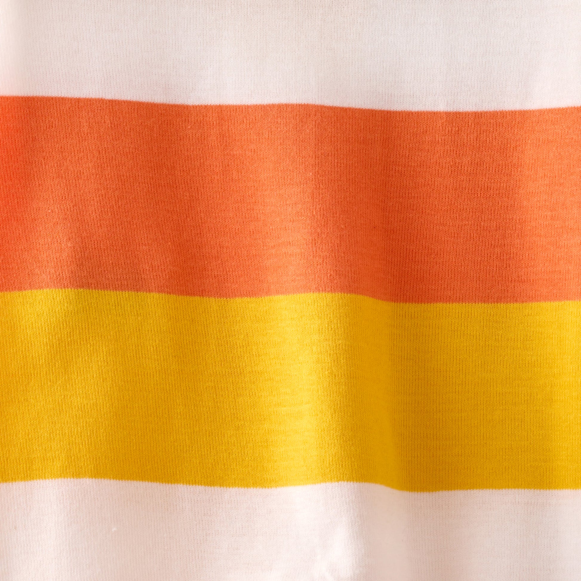 Close-up of fabric with orange, red, and yellow horizontal stripes on a white background