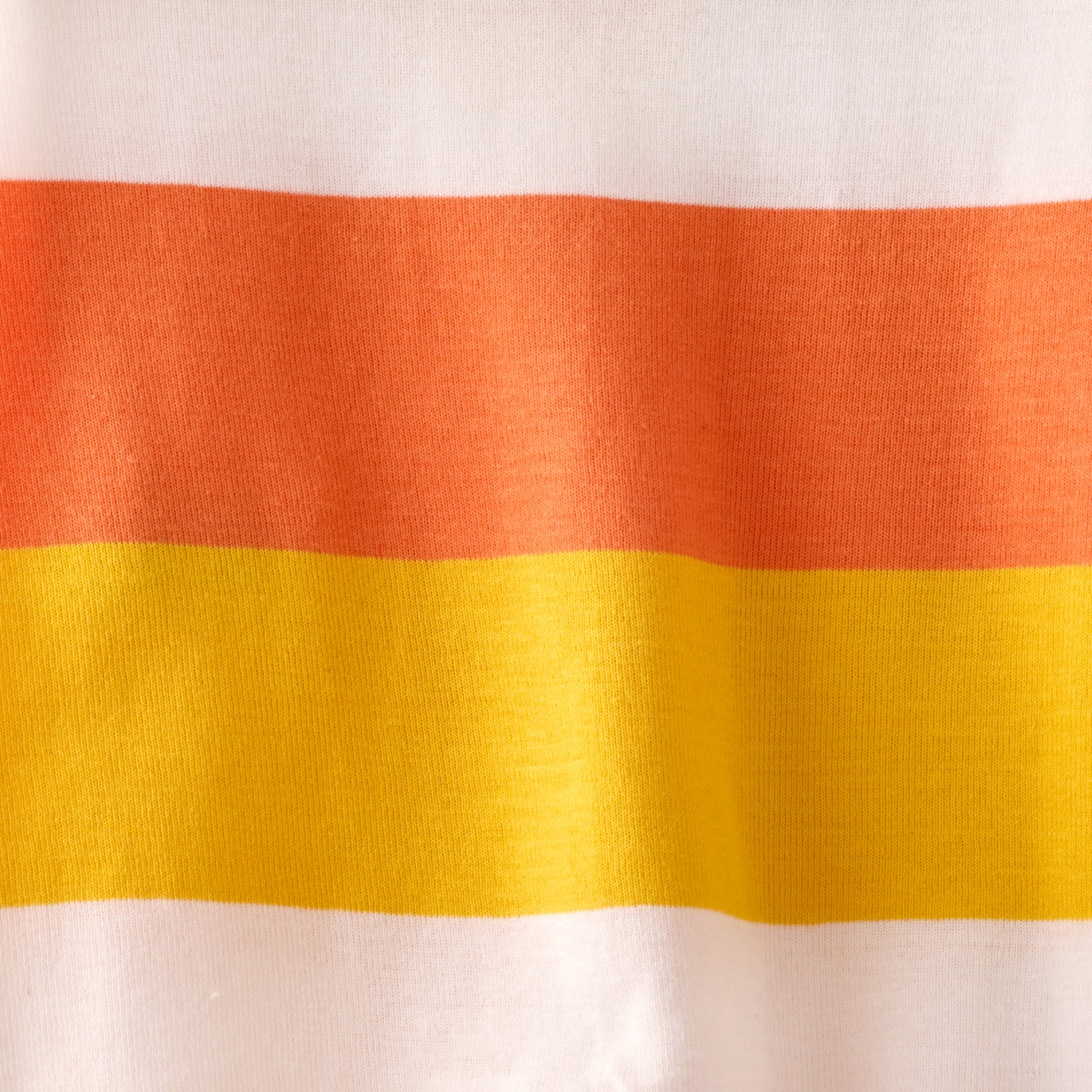 Close-up of fabric with orange, red, and yellow horizontal stripes on a white background
