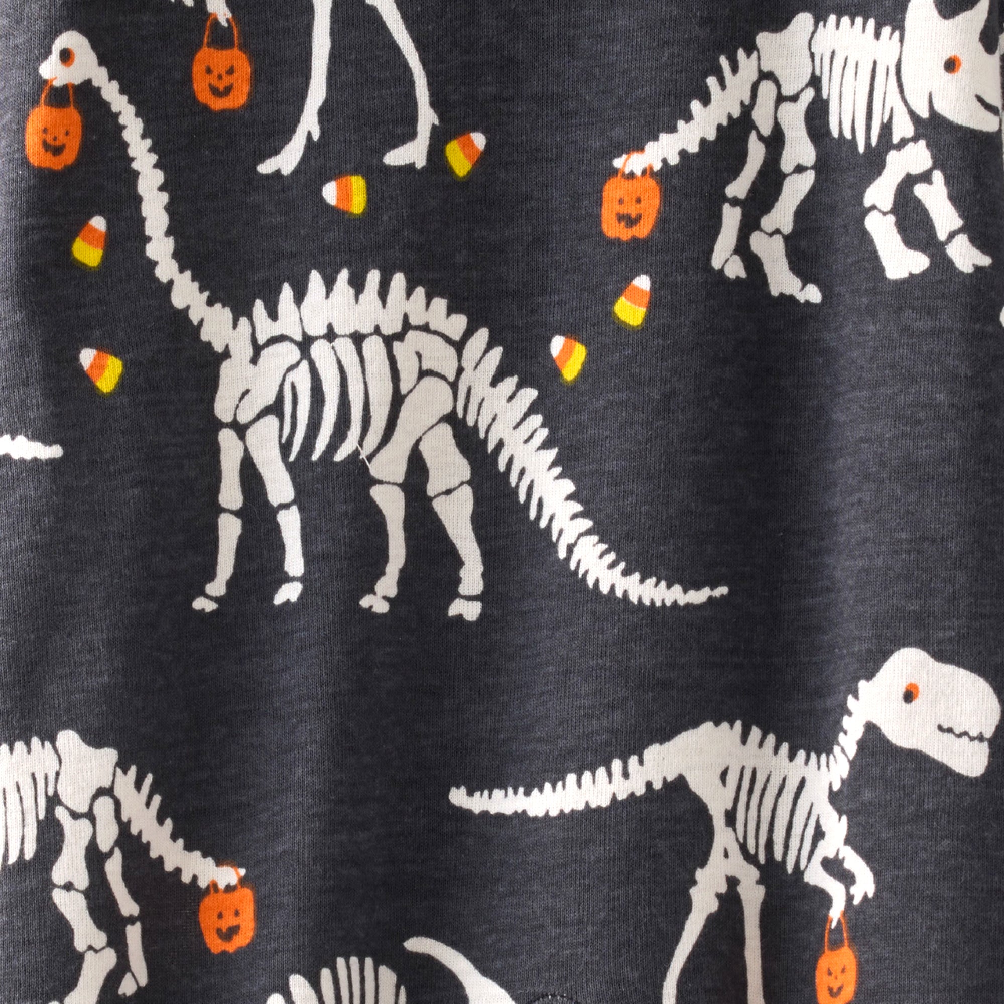Dinosaur skeletons with Halloween elements on a dark background
