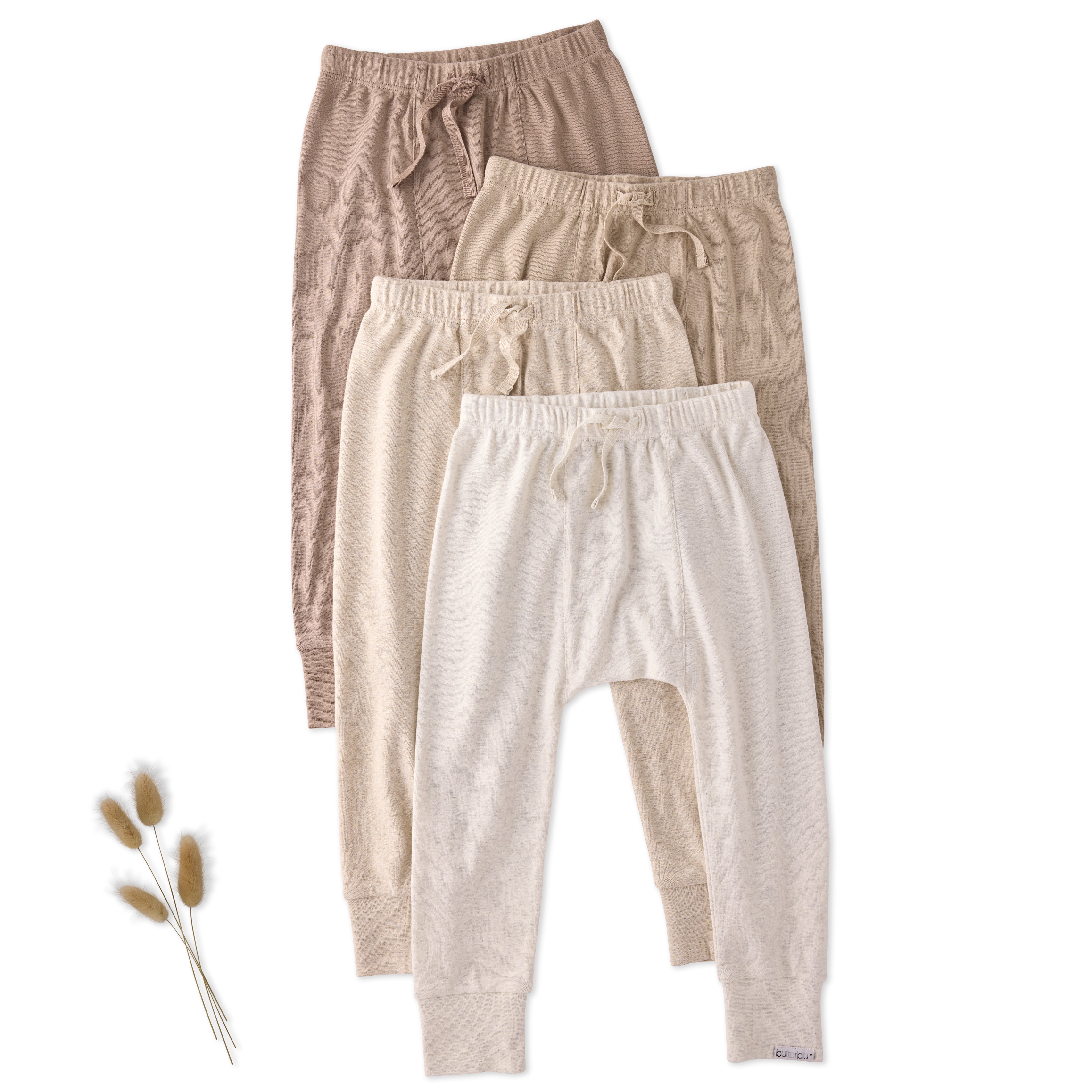 Three pairs of kids pants in beige, brown, and white on a white background.