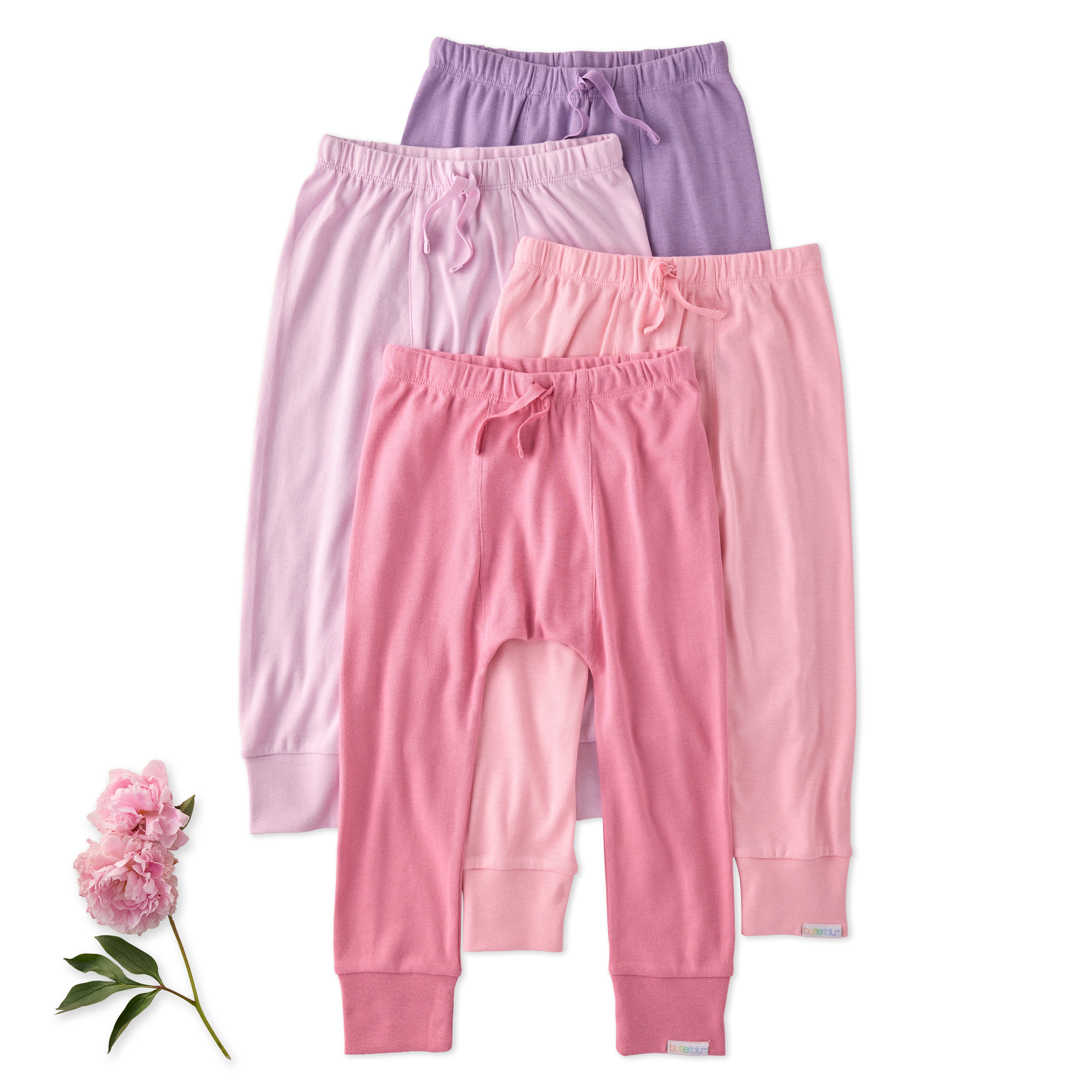 Three pairs of pink and purple baby pants with a pink flower on a white background
