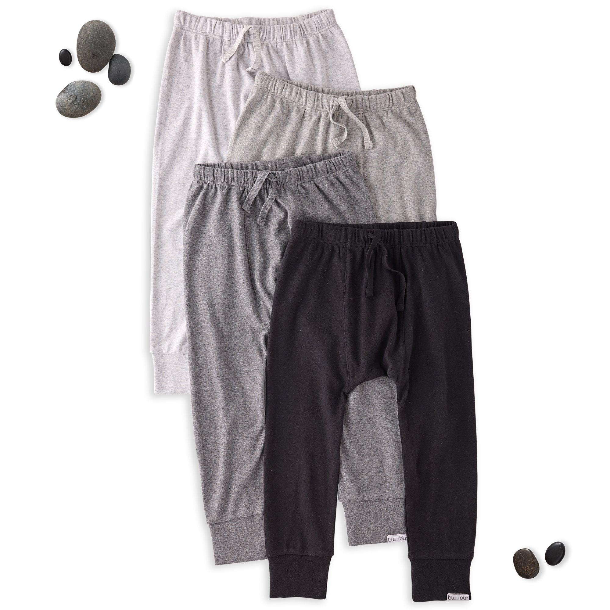 Three pairs of kids pants in black, gray, and white on a white background.