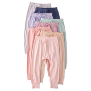 Set of pastel-colored baby pants stacked on a white background