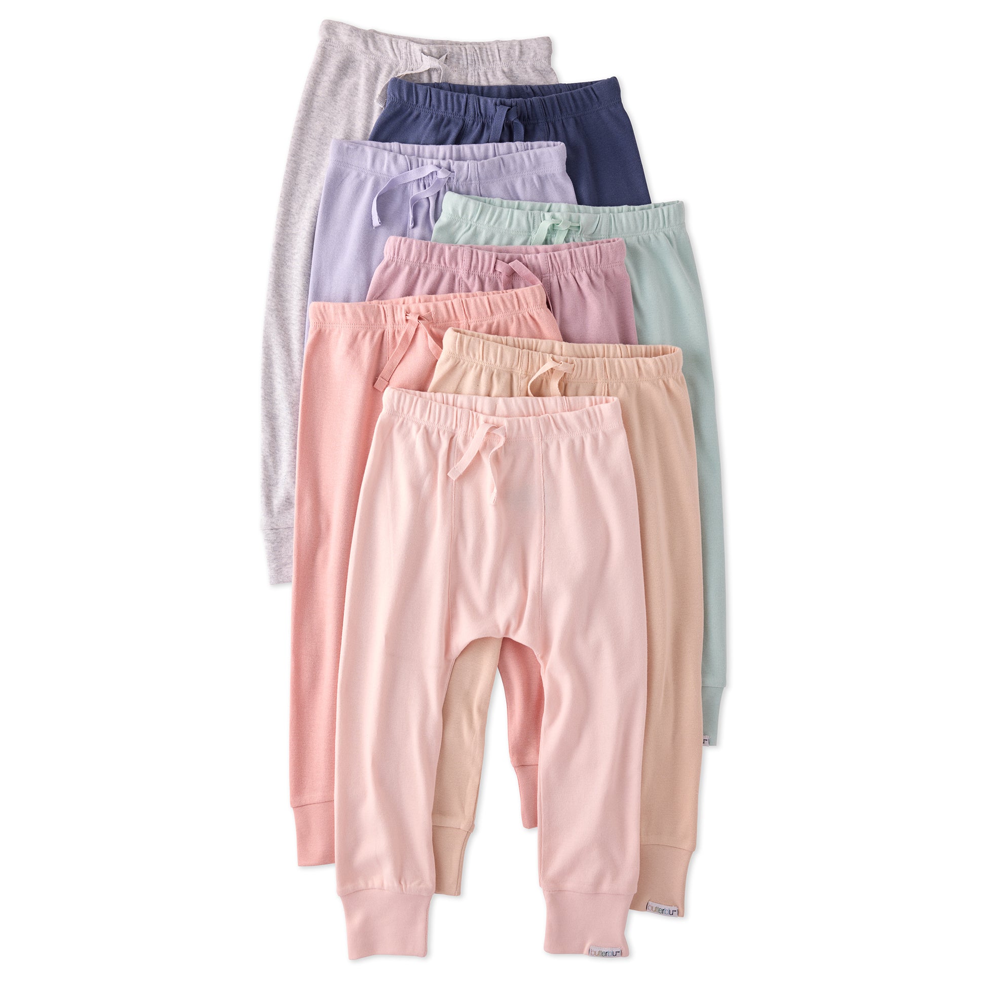 Set of pastel-colored baby pants stacked on a white background