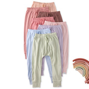 Set of pastel-colored pants stacked on a white background with a rainbow color swatch.