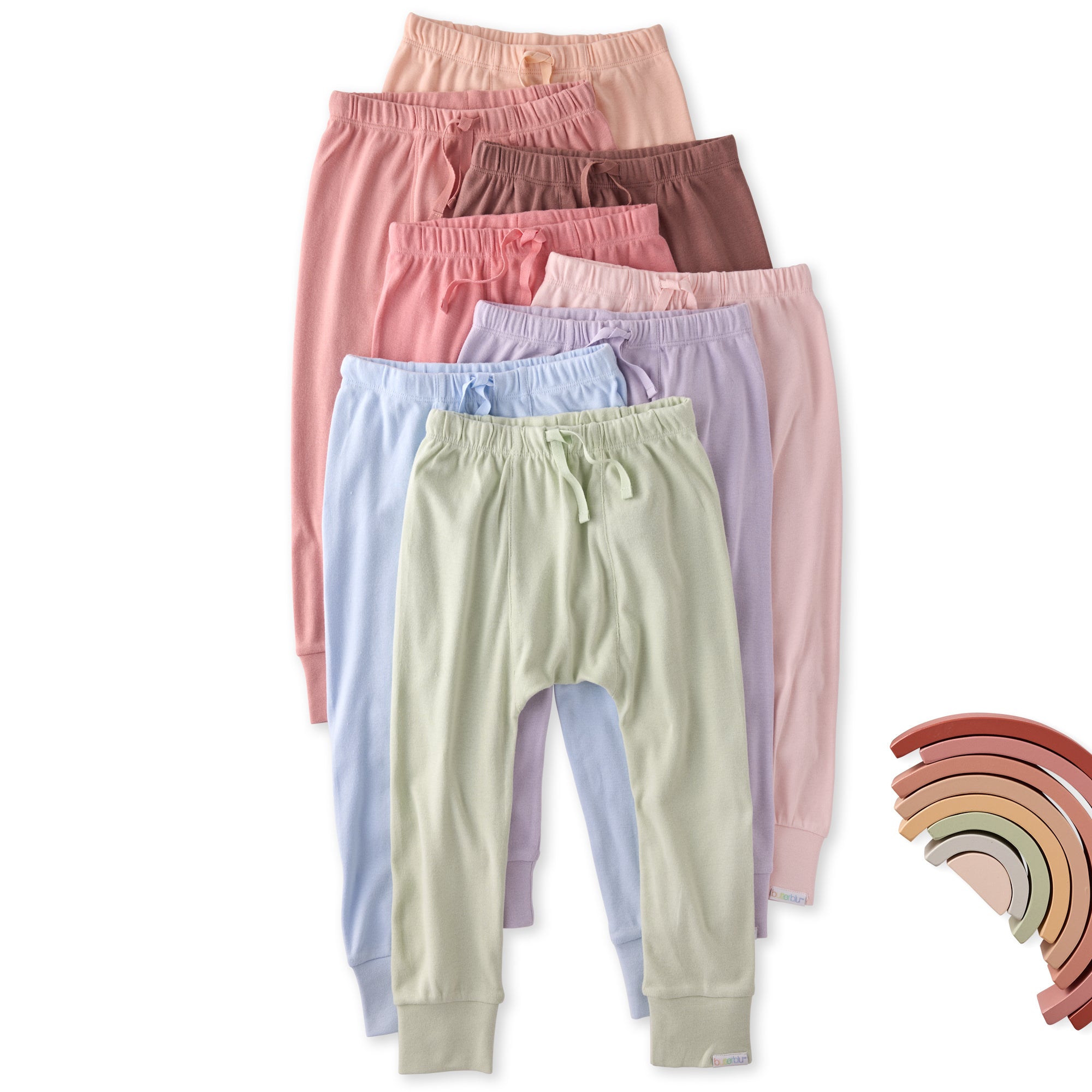 Set of pastel-colored pants stacked on a white background with a rainbow color swatch.