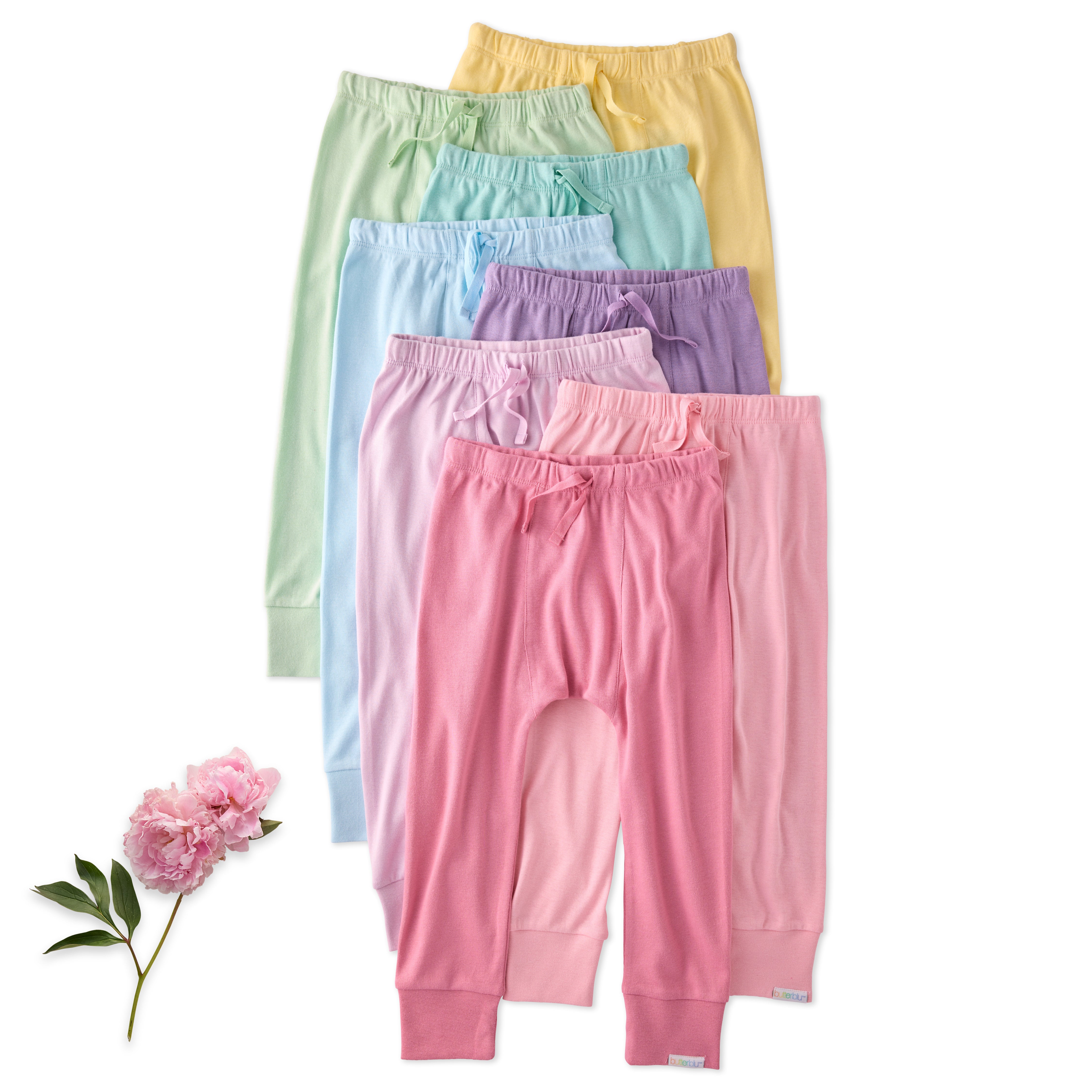 Set of pastel-colored baby pants with a pink flower on a white background